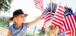 Child in hat holding an American Flag